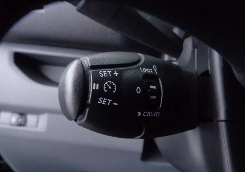 Gros plan sur la commande de régulateur de vitesse du Peugeot Expert Fourgon noir métal, intérieur conducteur.