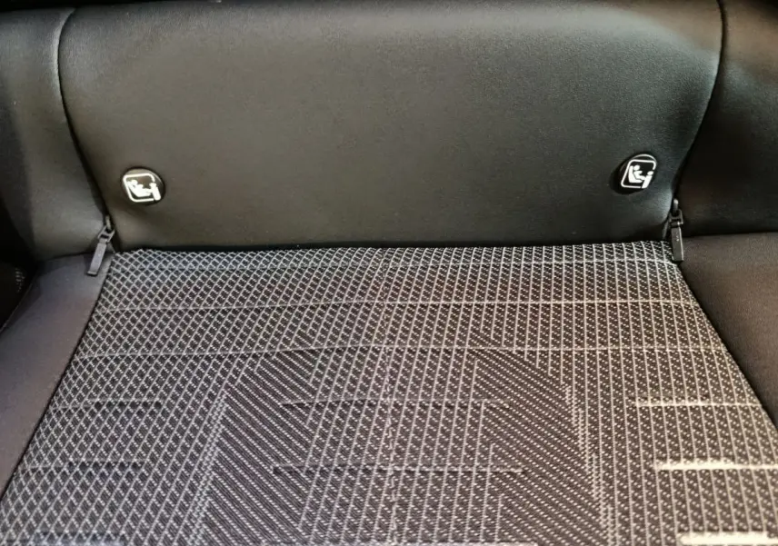 Gros plan sur la banquette arrière noire et la texture du coffre du Peugeot 3008 gris foncé hybride 2025.