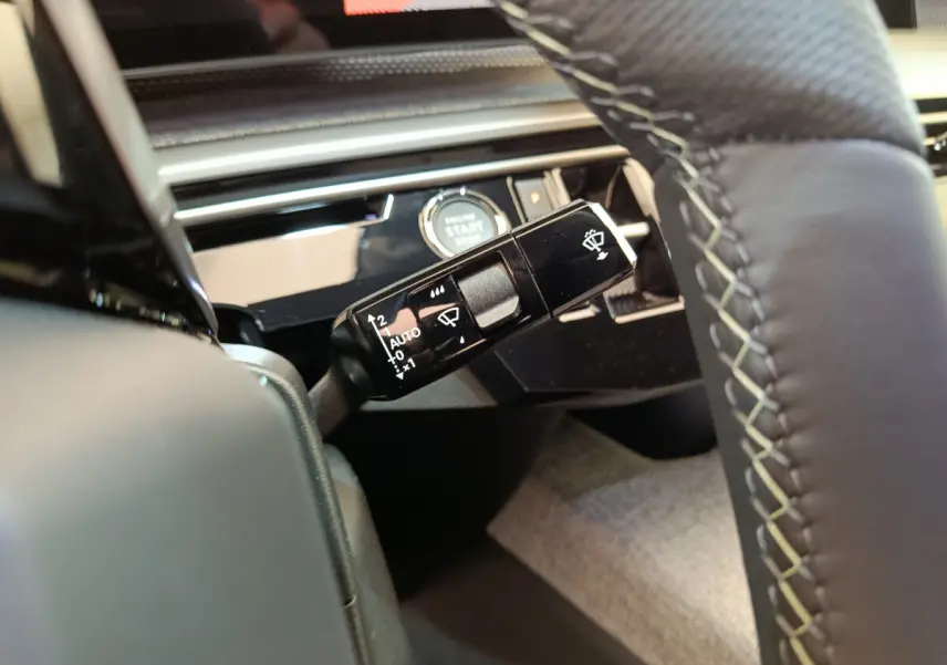 Gros plan sur la commande d'essuie-glace à gauche du volant cuir du Peugeot 3008 gris foncé 2025.