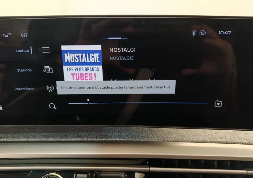 Écran tactile central du tableau de bord du Peugeot 3008 gris foncé, affichant la radio Nostalgie.