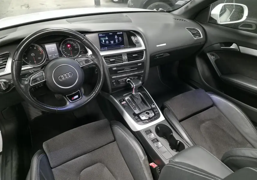 Intérieur noir de l'Audi A5 Cabriolet 2014, vue de face sur le tableau de bord et le volant multifonction S Line.