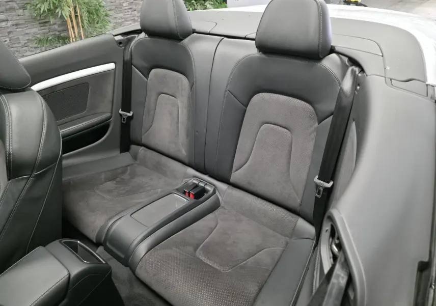Vue rapprochée des sièges arrière en cuir noir et alcantara de l'Audi A5 Cabriolet blanc de 2014.