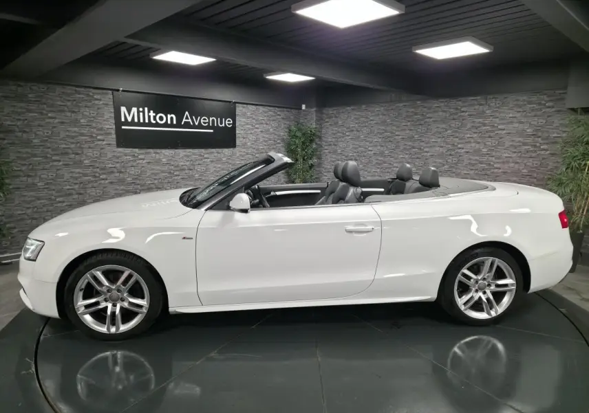 Audi A5 Cabriolet blanc vue de profil côté gauche, capote ouverte et jantes aluminium sport 5 branches doubles