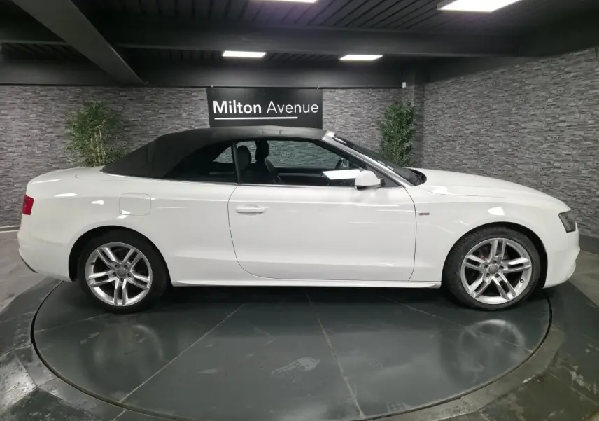 Audi A5 Cabriolet blanc vue de profil côté gauche avec capote noire et jantes aluminium sport 5 branches doubles