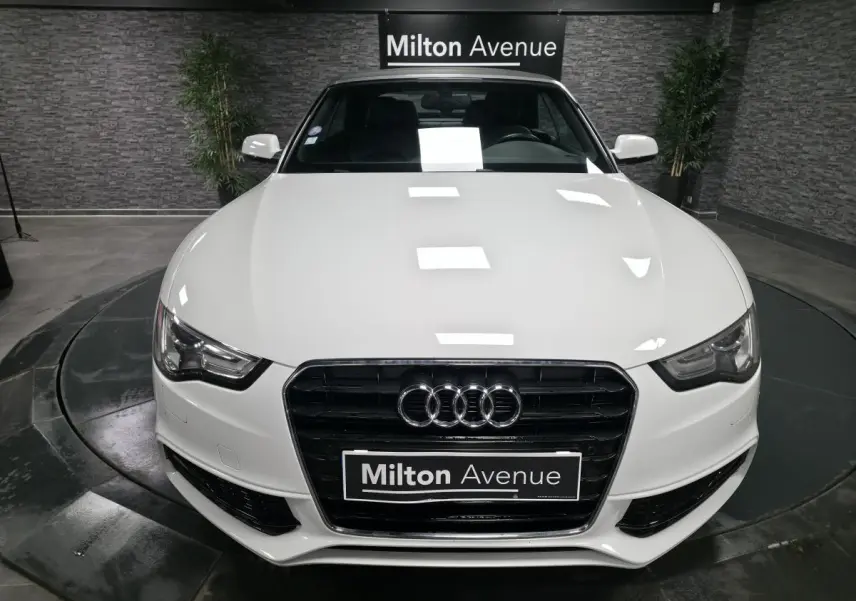 Vue avant d'un Audi A5 Cabriolet blanc avec calandre Singleframe noire et logo quatre anneaux bien visible