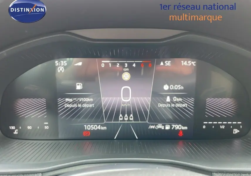 Vue rapprochée du tableau de bord numérique de la Skoda Scala blanc glacier, affichant la vitesse à 0 km/h et 10504 km au compteur.