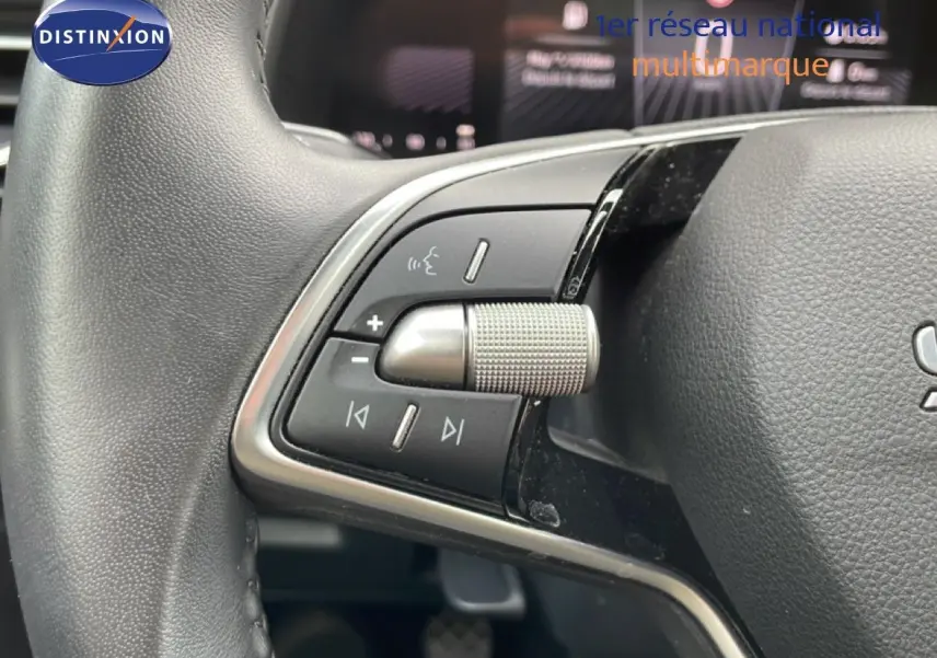 Gros plan sur les commandes multifonctions au volant d’une Skoda Scala 2025, finition tissu gris-noir.