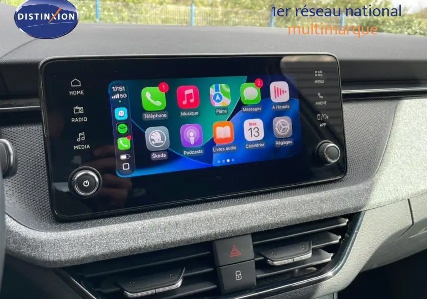 Vue rapprochée de l’écran tactile central du tableau de bord de la Skoda Scala blanc glacier 2025, affichant les applications connectées.