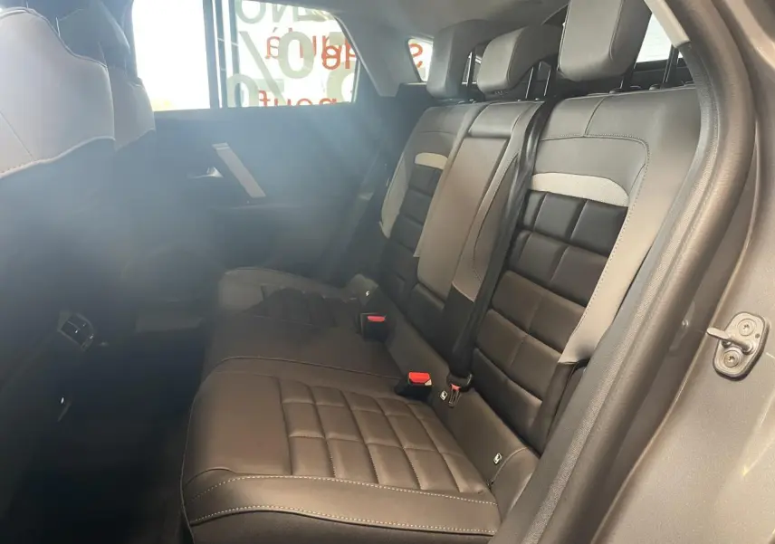 Vue intérieure côté droit des sièges arrière en cuir noir et gris clair de la Citroën C4 hybride 2026.