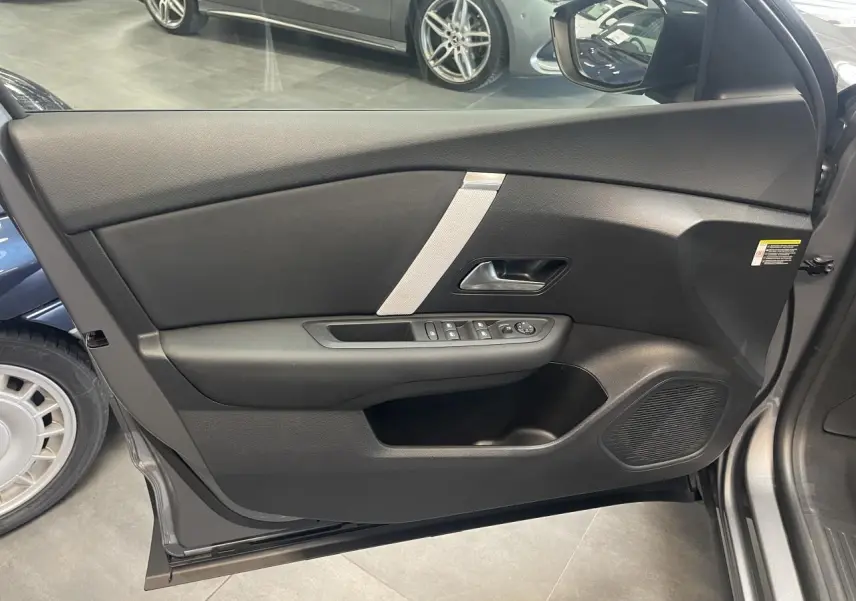 Vue intérieure côté gauche de la porte avant gris métallisé de la Citroën C4 avec commandes de vitres et haut-parleur intégré.