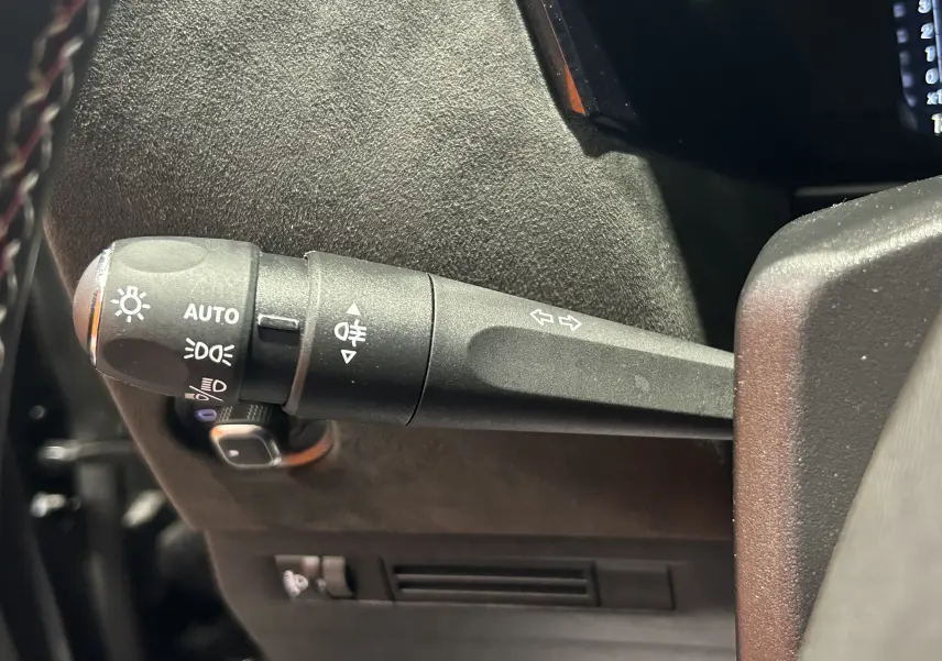 Gros plan sur la commande des phares et clignotants à gauche du volant d'une DS4 2024 noir Perla Nera.