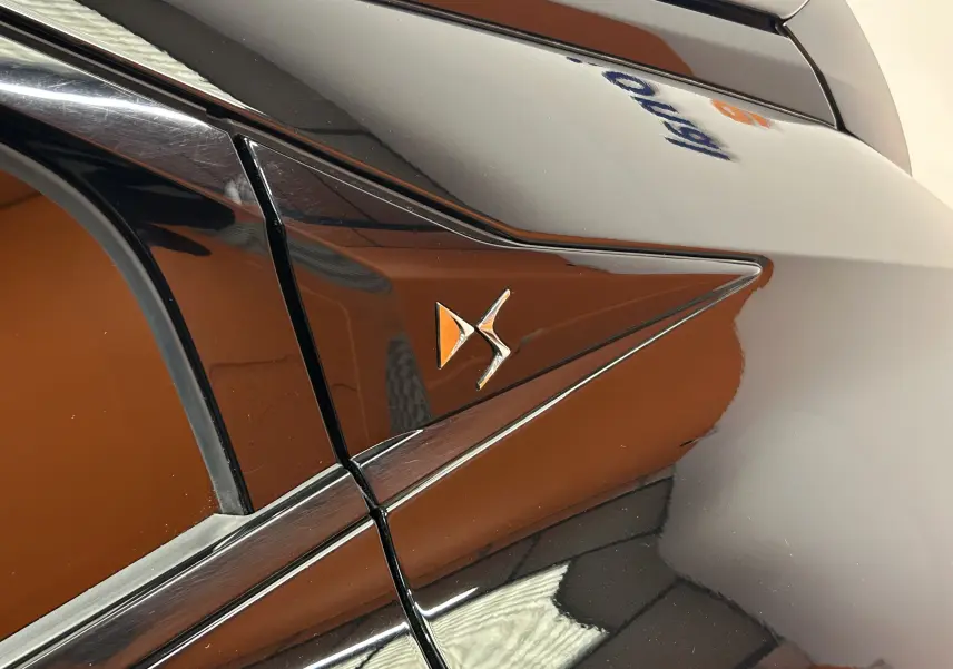 Détail du logo DS sur la carrosserie noire Perla Nera côté gauche arrière du DS4 2024.