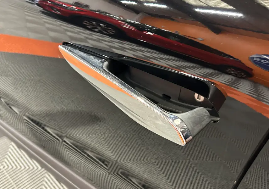 Poignée de porte chromée en gros plan sur la portière côté droit d'une DS4 Noir Perla Nera 2024.