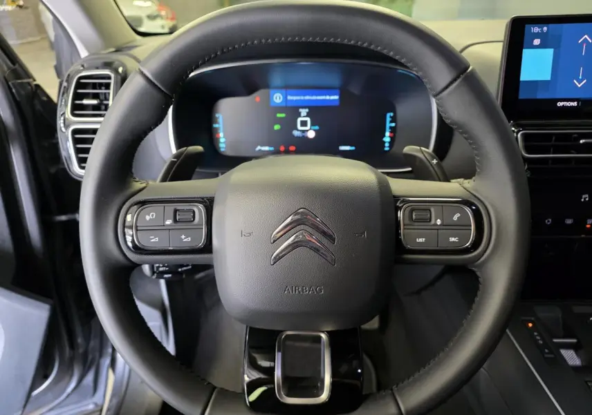 Volant cuir noir avec commandes intégrées et combiné numérique du Citroën C5 Aircross Hybrid 2024 vu de face.