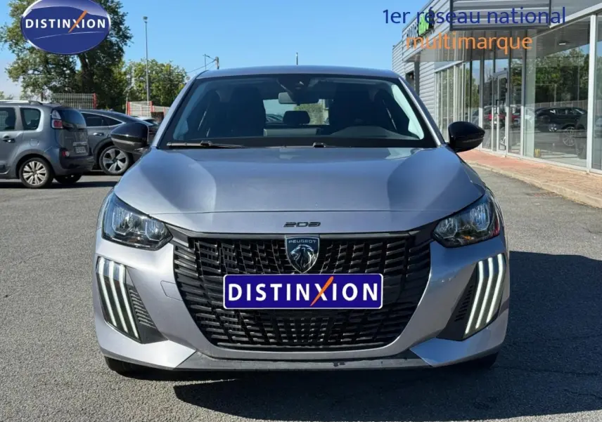 Vue avant d'une Peugeot 208 gris Artense avec calandre noire et feux LED verticaux distinctifs.