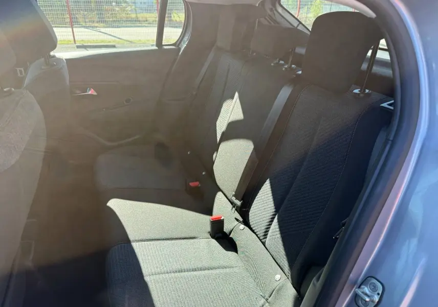 Vue intérieure côté gauche montrant la banquette arrière en tissu gris avec ceintures de sécurité sur une Peugeot 208 2025.