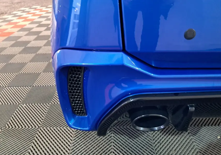 Gros plan sur le coin arrière droit bleu d'une Aixam Ambition 2025 avec sortie d'échappement et prise d'air noire.
