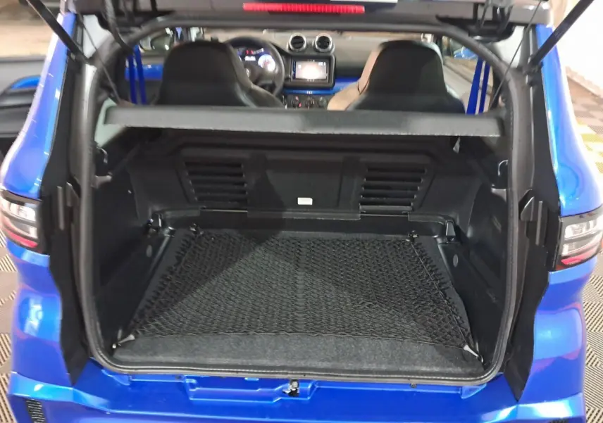 Coffre ouvert d'une Aixam Ambition bleu 2025, vue arrière montrant l'intérieur et les sièges avant.