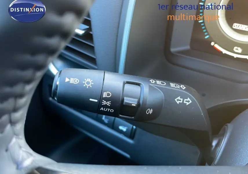 Commande des feux et clignotants en gros plan à gauche du volant du Nissan Qashqai gris argile 2025.