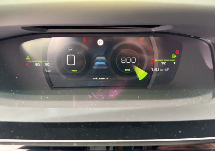 Tableau de bord numérique Peugeot 308 2026 affichant vitesse, régime moteur et alertes, vue frontale rapprochée.