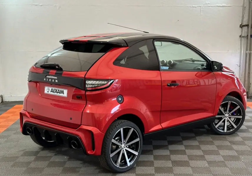 Aixam Ambition 0.5 City Coupe GTI rouge vue 3/4 arrière droit avec toit noir et jantes sport noires et argentées.