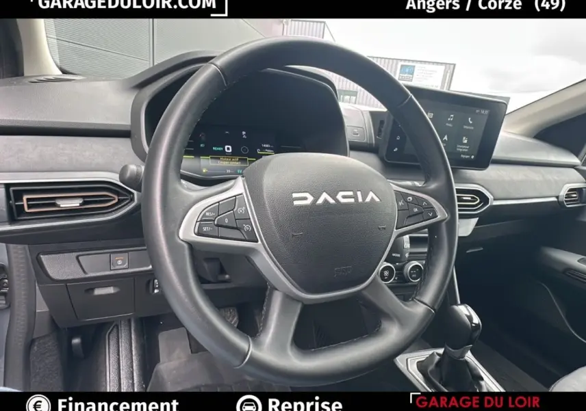 Vue intérieure centrée sur le volant noir du Dacia Jogger Extreme+ Hybrid 2025 avec tableau de bord digital et écran tactile.