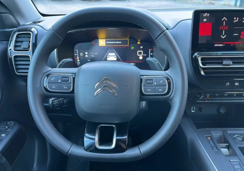 Vue centrée sur le volant cuir multifonctions du Citroën C5 Aircross Hybrid 2025 avec tableau de bord digital et écran tactile.