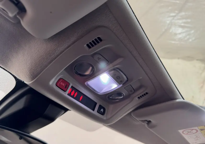 Plafonnier intérieur allumé avec commandes et bouton SOS dans une Citroën C3 noire de 2019.