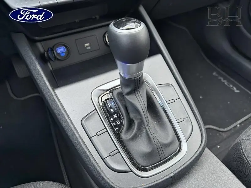 Le levier de vitesses automatique du Hyundai Kona 1.6 GDi Hybrid en vue plongeante sur console noire avec tapis marqué Kona.