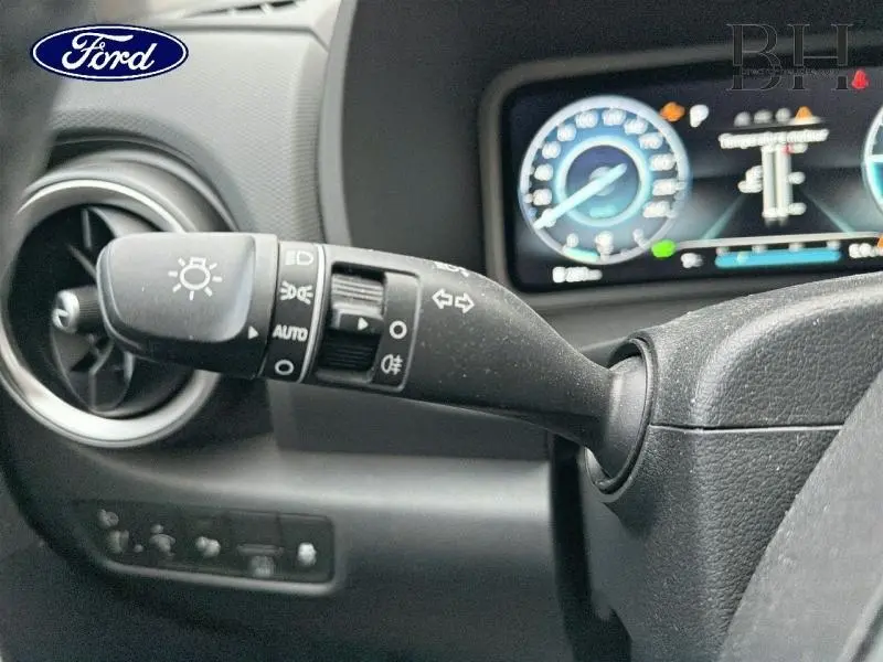 Le levier de clignotant et commandes d'éclairage sur le côté gauche du volant d'une Ford, tableau de bord en arrière-plan.