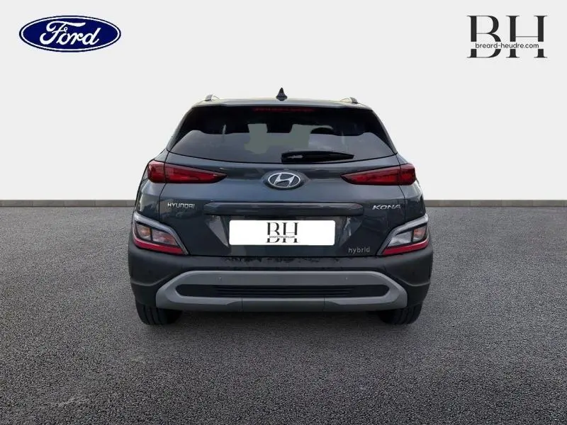 Vue arrière d'une Hyundai Kona Cyber Grey Métal 2021 hybride avec feux arrière étirés et logo Hyundai visible.