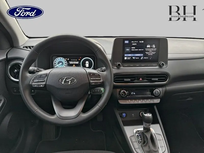 Intérieur du Hyundai Kona 2021 avec tableau de bord noir, volant cuir multifonction et écran tactile central visible de face.