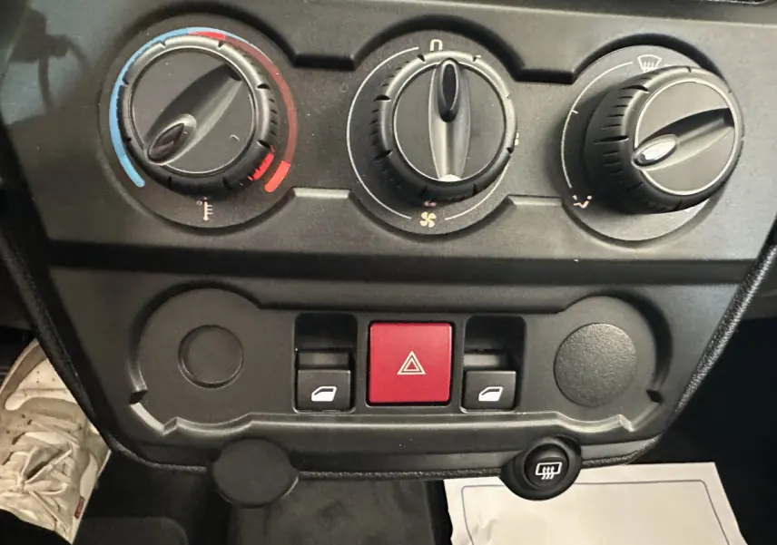 Tableau de bord de l'AIXAM AMBITION 0.5 CITY PACK 2025 montrant les commandes de climatisation et les boutons d'alerte.