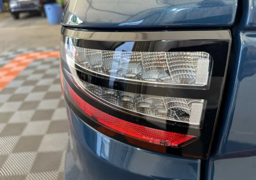 Gros plan sur le feu arrière droit bleu de l'AIXAM AMBITION 0.5 CITY PACK 2025 avec détails lumineux précis.