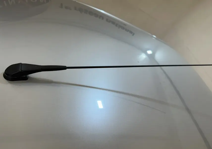 Gros plan sur l'antenne radio noire sur le toit bleu d'une Aixam Ambition 0.5 City Pack 2025 vue de dessus.