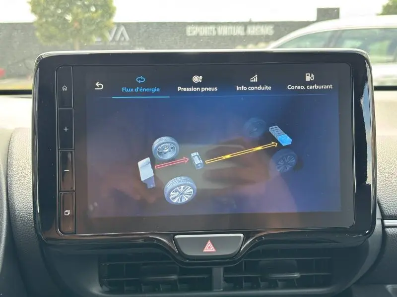 Écran tactile intérieur de la Toyota Yaris 116h Dynamic 2025 montrant le flux d'énergie hybride en fonctionnement.