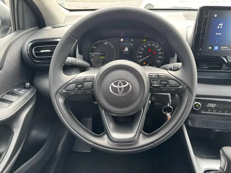 Vue frontale du volant et tableau de bord de la Toyota Yaris 116h Dynamic 5p MC24 2025, intérieur noir avec écran tactile.