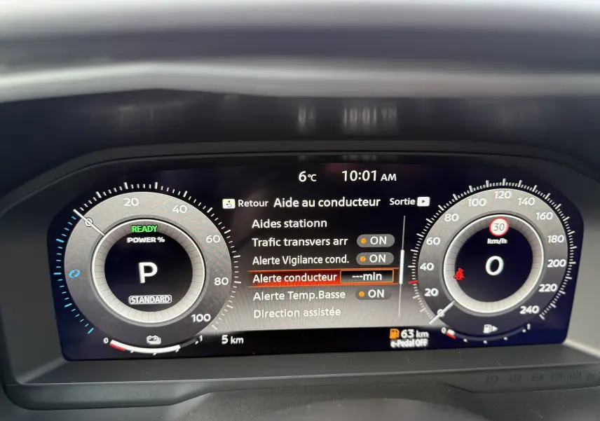 Vue intérieure du tableau de bord numérique du Nissan Qashqai 2025, affichant les aides au conducteur et la vitesse à 0 km/h.