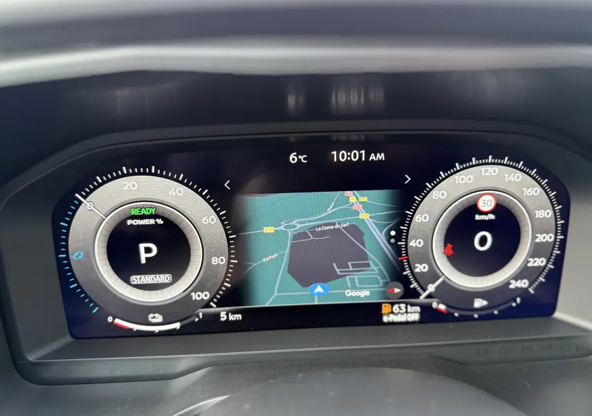 Tableau de bord numérique du Nissan Qashqai 1.5 E-POWER 2025, affichant vitesse, navigation et température extérieure.