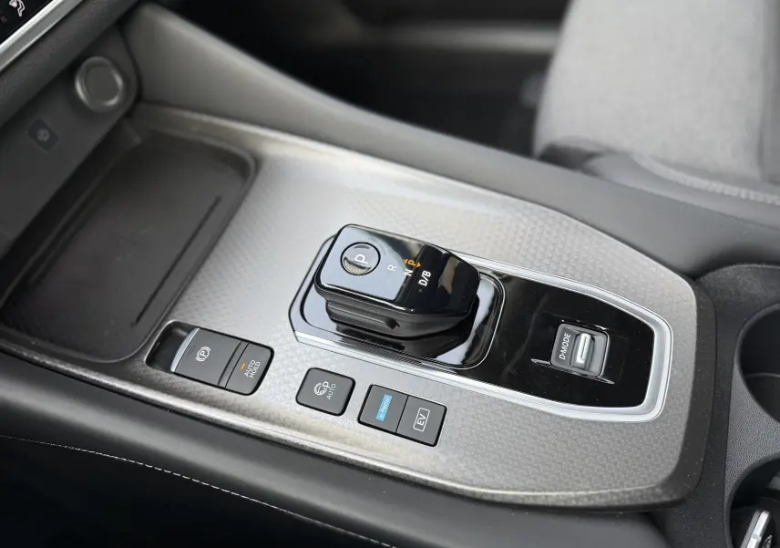 Gros plan sur la console centrale du Nissan Qashqai 2025 gris, mettant en valeur le sélecteur de vitesse électronique et les boutons de commande.