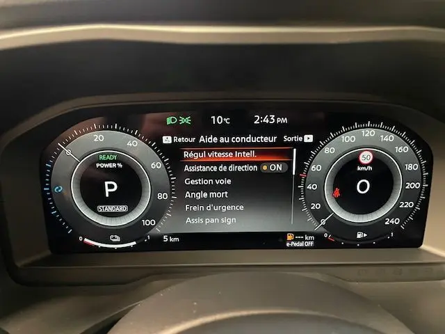 Tableau de bord numérique du Nissan Qashqai 1.5 E-POWER 2025, affichant les aides à la conduite et la vitesse à 0 km/h.