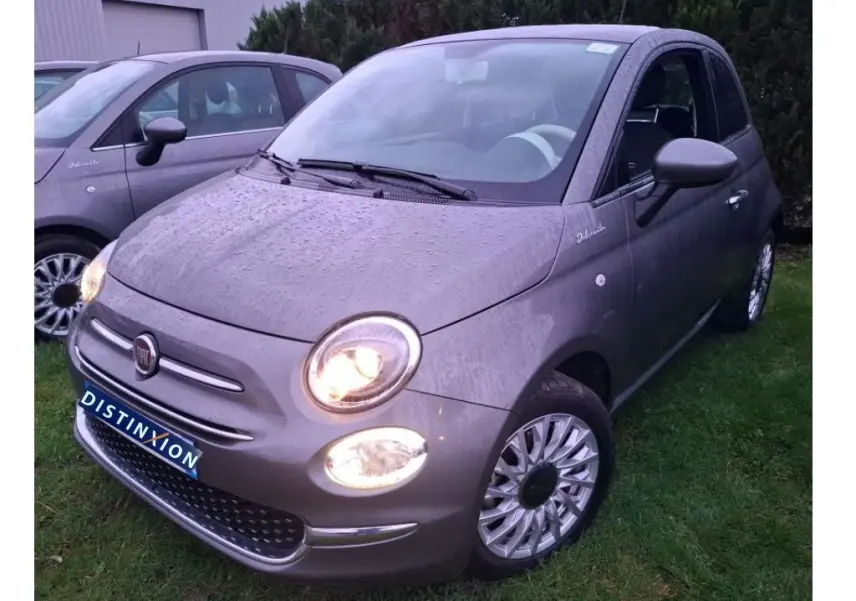 Vue 3/4 avant droite d'une Fiat 500 gris Electroclash avec phares allumés et jantes spécifiques Dolcevita.
