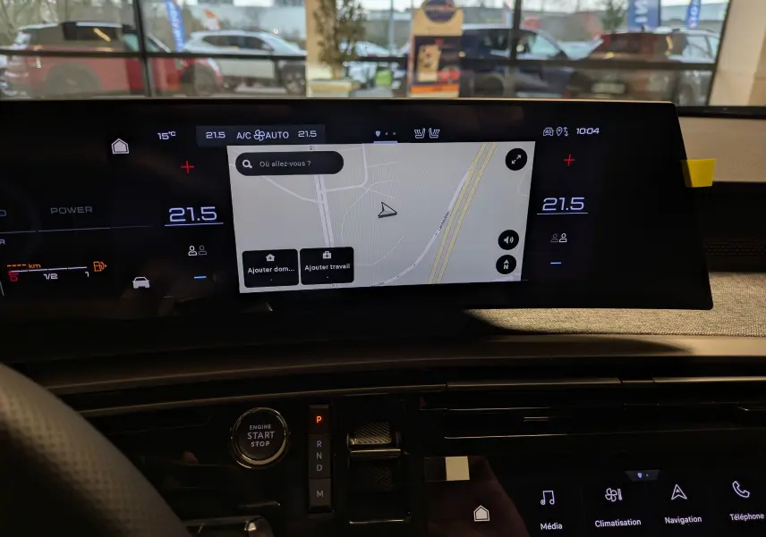 Vue intérieure du tableau de bord du Peugeot 3008 Hybrid 145 GT, écran tactile central affichant la navigation et commandes digitales.