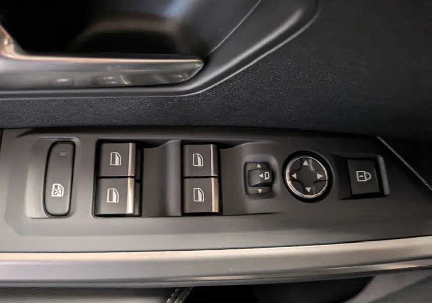 Gros plan sur les commandes de lève-vitres et rétroviseurs côté conducteur du Peugeot 3008 gris titane avec insert alu.