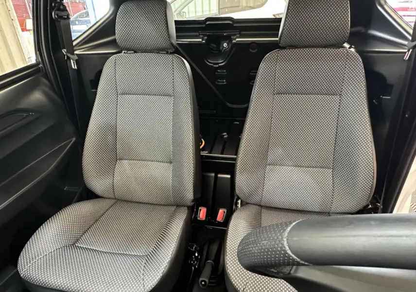 Vue intérieure rapprochée des sièges avant gris à motifs de l'AIXAM MINAUTO E ACCESS 2025, côté conducteur visible.