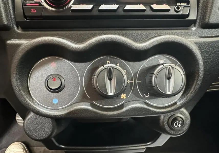 Gros plan sur les commandes de climatisation noires de l'AIXAM MINAUTO E ACCESS 2025 avec réglages manuels et bouton antibrouillard.