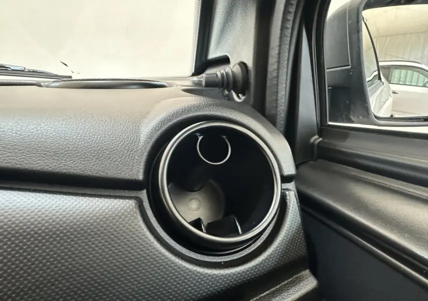 Gros plan sur la sortie d'air circulaire côté conducteur de l'AIXAM MINAUTO E ACCESS blanc, avec rétroviseur extérieur caméra visible.