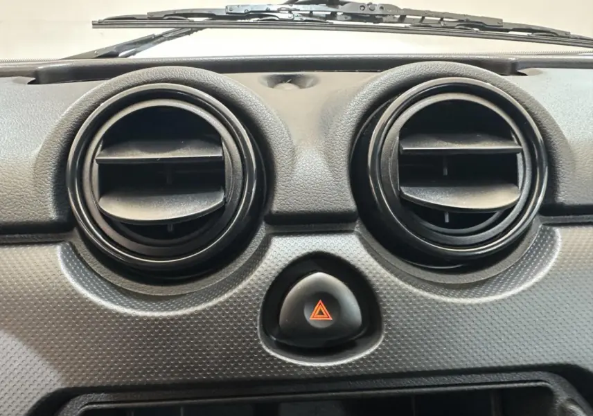 Gros plan sur les aérateurs ronds et le bouton de warning du tableau de bord d'une Aixam MINAUTO E ACCESS blanc 2025.