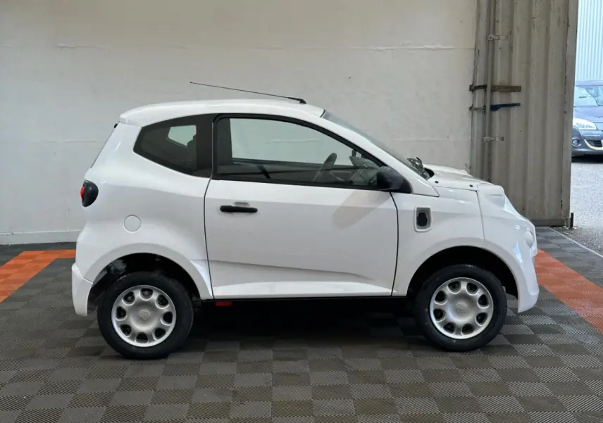 Profil droit d'une microcar AIXAM MINAUTO E ACCESS blanche de 2025 avec rétroviseur caméra côté conducteur.