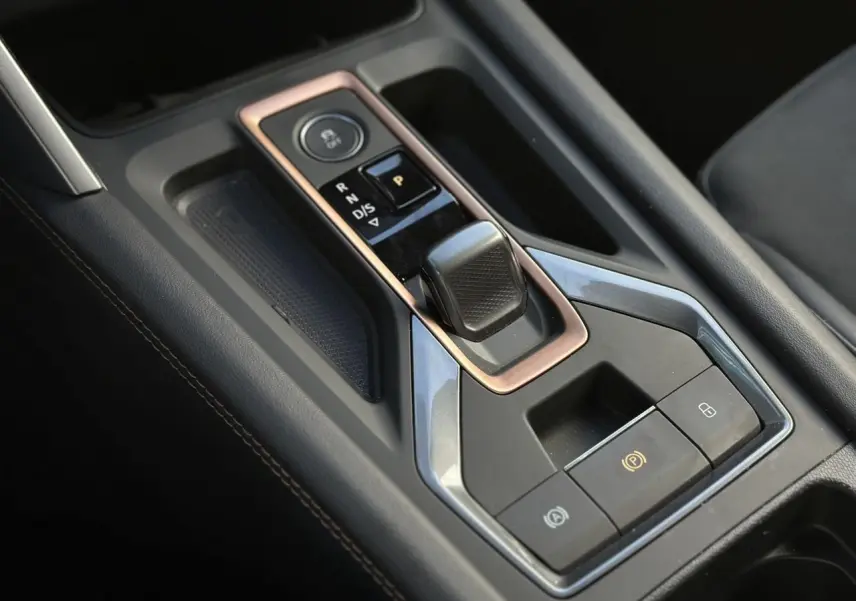 Vue rapprochée de la console centrale noire avec sélecteur de vitesse électronique et commandes du CUPRA Formentor blanc Neige.